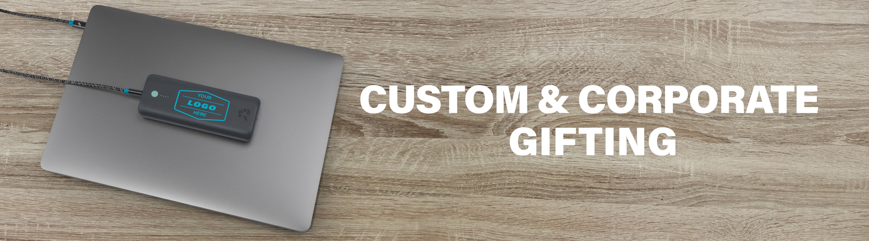 A Nimble power bank with a customizable logo is placed on a laptop against a wooden surface, accompanied by the text Custom & Corporate Gifting.