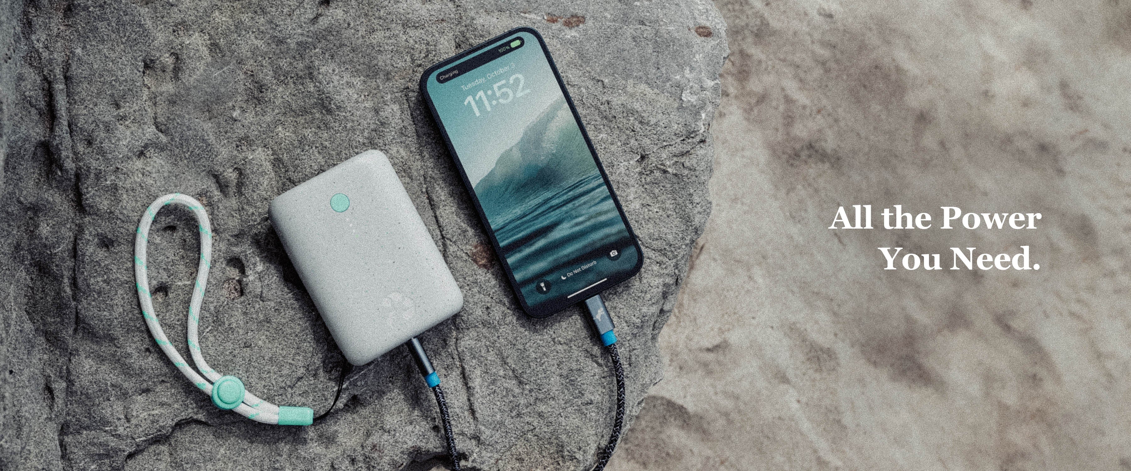 Banner image showing a white Champ battery charging an iPhone on a rock with sand in the background. Text overlay All the Power You Need.