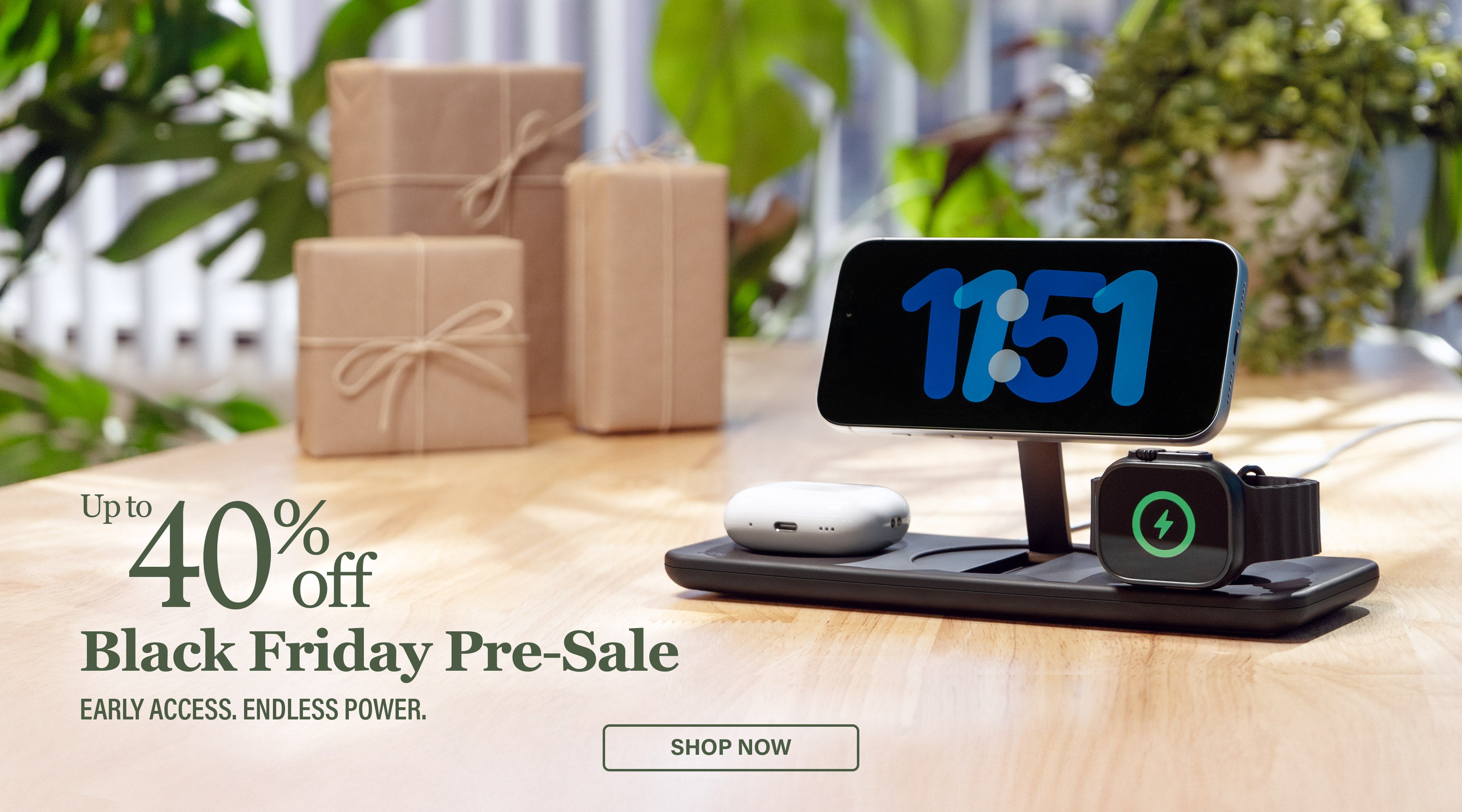 Podium 3-in-1 Wireless charger with clock on screen and Apple Watch and AirPods on a wooden surface with gift boxes and plants in the background.