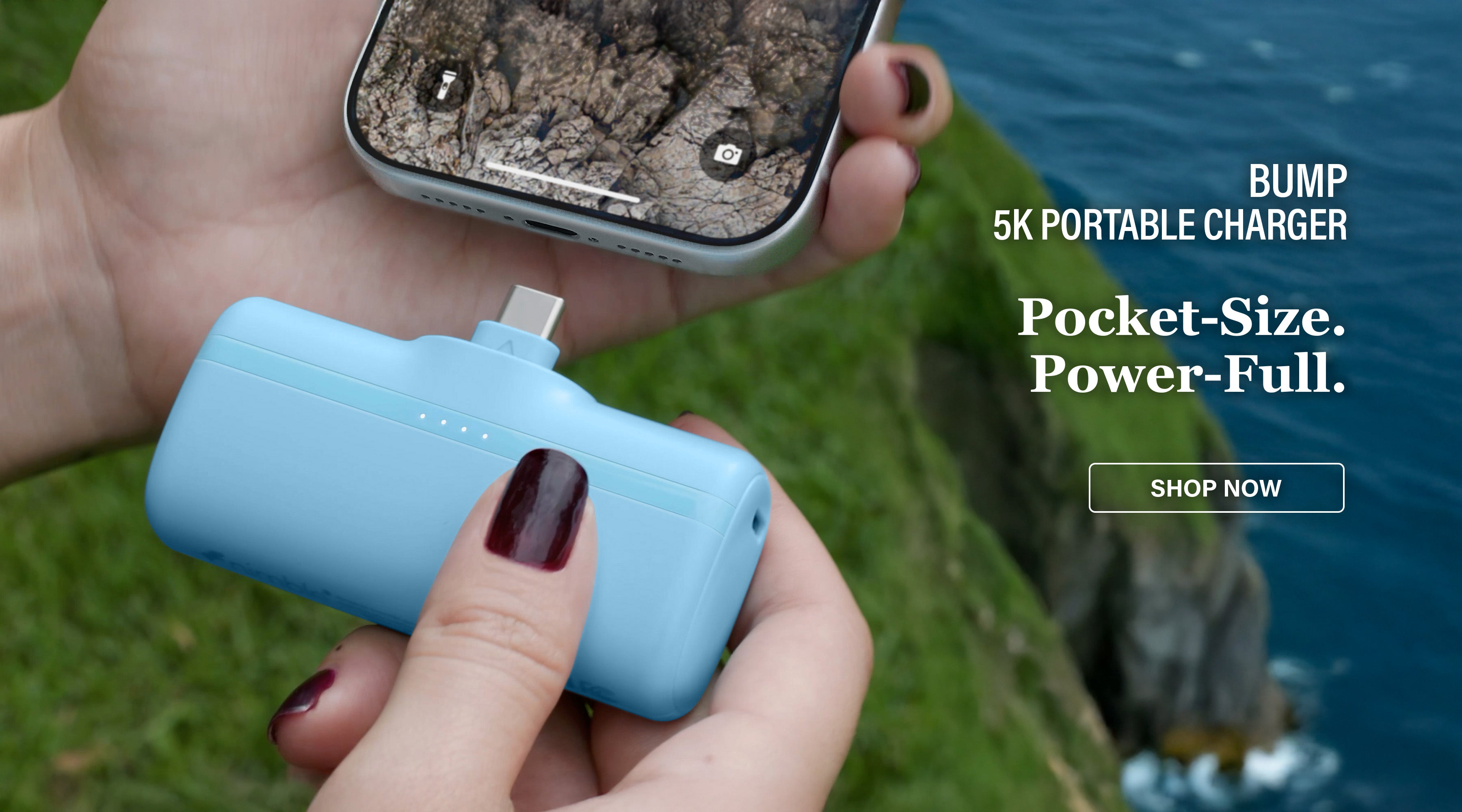 Person holding an iPhone and a blue portable charger with outdoor background and text overlay BUMP 5 Portable Charger. Pocket-Size. Power-Full. SHOP NOW.