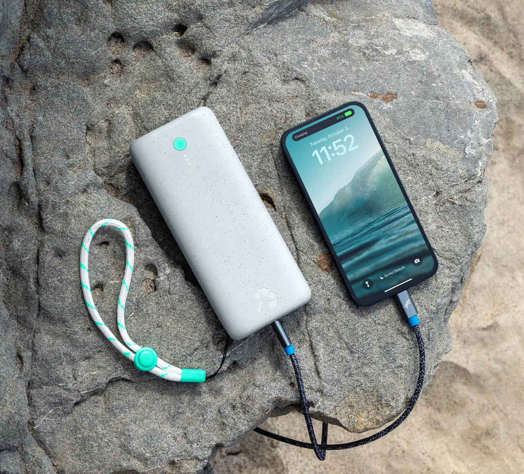 Smartphone and Nimble power bank charging on a rocky surface.