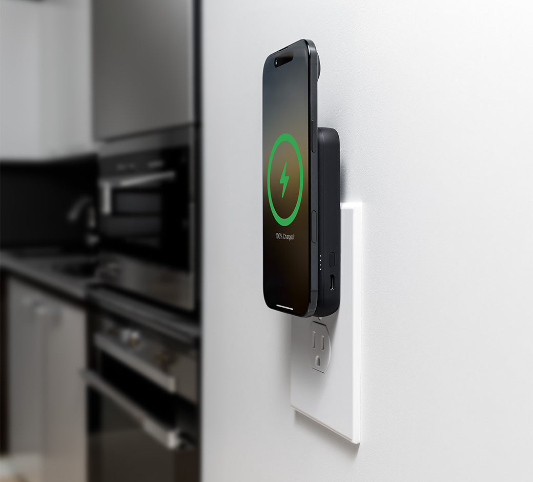 Phone being charged with a Wally Pro Wireless at an outlet in a kitchen.